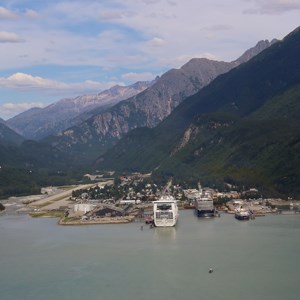 A view of a valley town and cruise ships at the edge of water