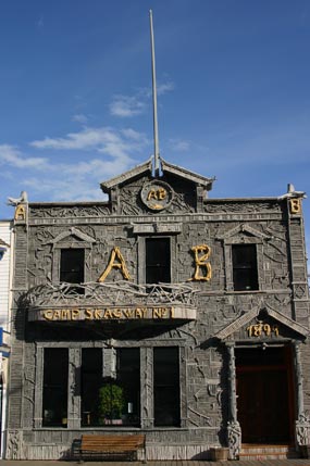 two story historic building the front covered with small pieces of driftwood