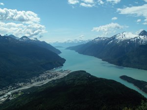 View of townsite and fjord surrounded by mountains from a mountain.
