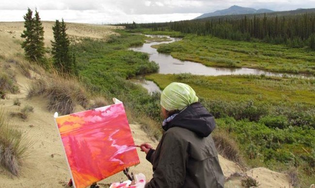 Artist painting the view along the edge of the sand dunes.