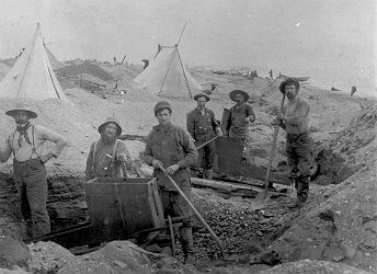 black and white photo of six men standing with mining equipment
