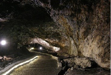 A lighted walkway goes off into the distance of a cave