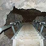 Steep stairs descending into a cave passage with a low ceiling