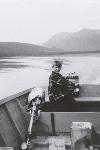 Girl in a skiff in front of her family's cabin on Lake Clark in 1952.