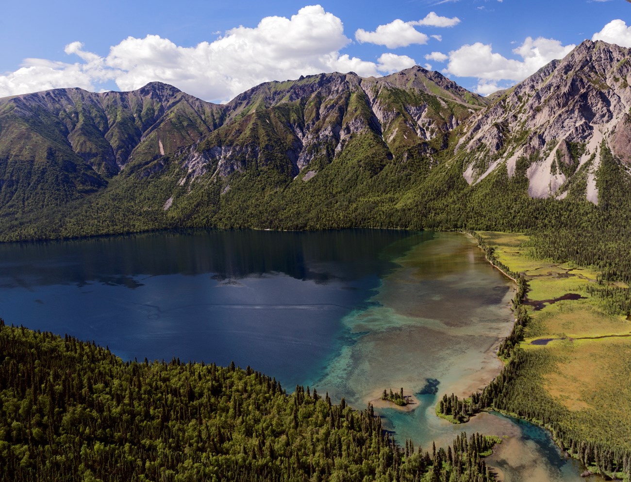 Aerial view of lake surrounded by mountains.