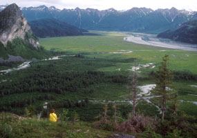 A hiker enjoys the view of Tuxedni Bay on the Lake Clark coast.