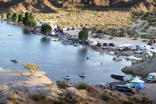 Photo from above water that is surrounded on three sides by boats, personal watercraft and RV's