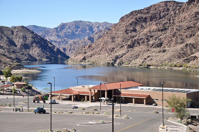 Elevated view of Willow Beach store, launch ramp and parking in foreground. Colorado River surrounded by rugged hills are in the background.
