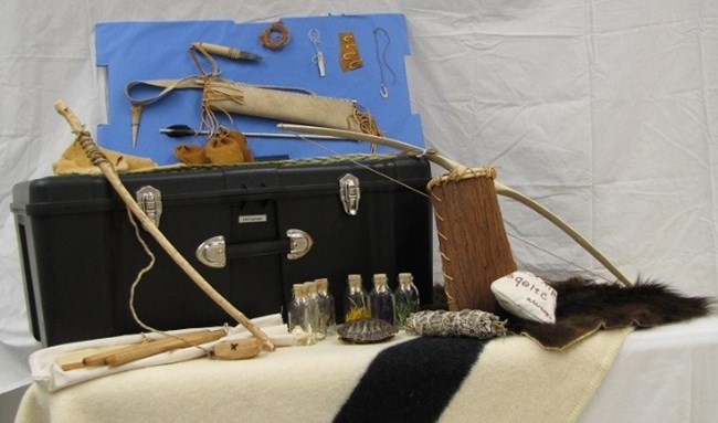 Contents of the trunk are displayed, including bow, furs, twine, arrows, arrowheads, and other small items.