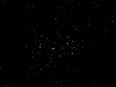 Photo of the asterism Pleiades: white spots of stars on a black background.
