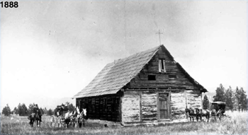 Black and white photo of St. Paul' Mission ca. 1888. People standing to the side. Horse and buggy in front.