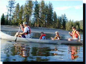 A family canoeing. Parents and two children paddling on the lake.