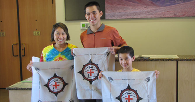Explore Safely trail challenge participants display their challenge bandanas.