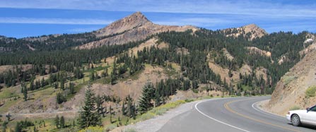 A vehicle faces Brokeoff Mountain and Mt. Diller on the park road. 