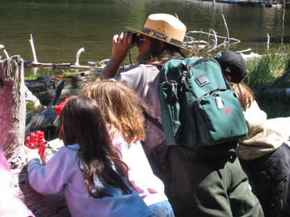 ranger and junior rangers look for birds on Manzanita Lake.