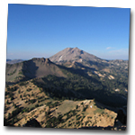 spine of dacite domes and remnants of old composite volcano with lassen peak in background and clear blue sky above.  As seen from Brokeoff Mountain