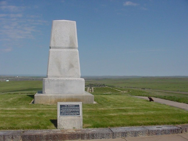 Tall gray stone monolith with soldiers names engraved across the face.