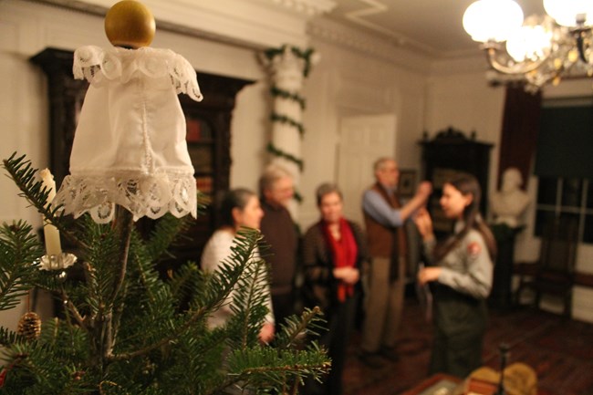 Christmas tree with ornament and visitors with ranger in background