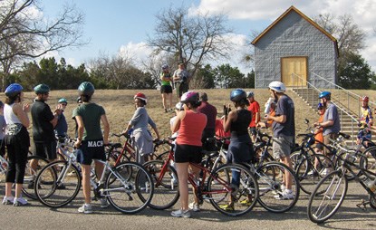 Luci Johnson speaks to cyclists outside the Junction School on the LBJ Ranch.