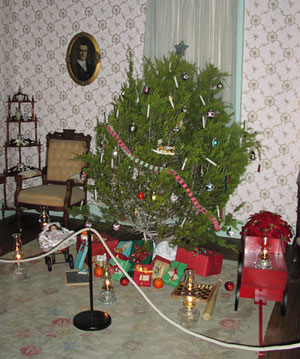 Old-fashioned Cedar Christmas Tree and presents in the parlor of the Boyhood Home.