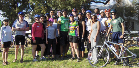 Luci Johnson stands with a group of cyclists in front of the Texas White House.