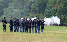 Historical re-enactors firing their muskets during military drill