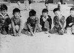 Line of little boys posing with a baseball