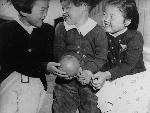 Three little girls laughing with a ball