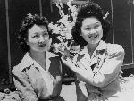 Two women display paper flowers