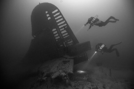 Divers from the NPS Submerged Resources Center inspect a sunken B-29 aircraft in Lake Mead
