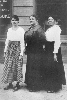 Maggie L Walker with two other women standing in front of the St. Luke Bank front windows