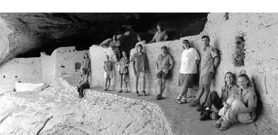 Thirteen archeologists posing in front of cliff dwelling at Gila Cliff Dwellings NM.