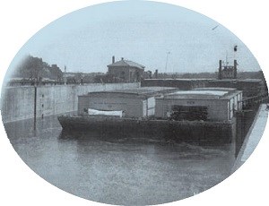 A double-wide barge locks through a dam.