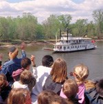 Kids welcome a paddleboat as it steams upriver.