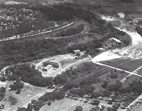 An aerial black and white photograph of the Bureau of Mines with the river in the background.