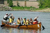 A large canoe filled with youth and leaders paddles down the Mississippi River.