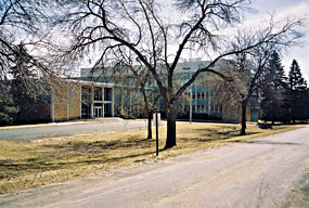 Building 1 of the Bureau of Mines, with its blue facade, sitting amidst leafless trees.