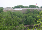 An old fort sits above the Mississippi River and wooded shorelines.