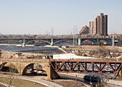 Large buildings beyond the famous Stone Arch Bridge that crosses the river at St. Anthony Falls.
