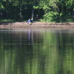 A man sits on the bank of the Mississippi River.