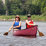 Two paddlers in a red canoe float the Mississippi River.