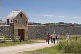 Visitors approach the gate of a historic stone fort.