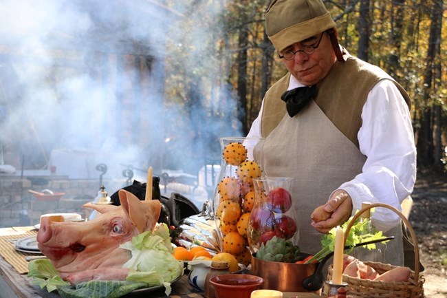 A cook examines his produce during a living history event at Moores Creek