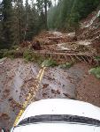 Mud and branches cover section of road.