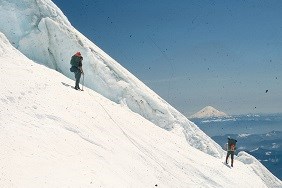 Climbers descending Tahoma Glacier with pre-1980 Mount St. Helens in the background