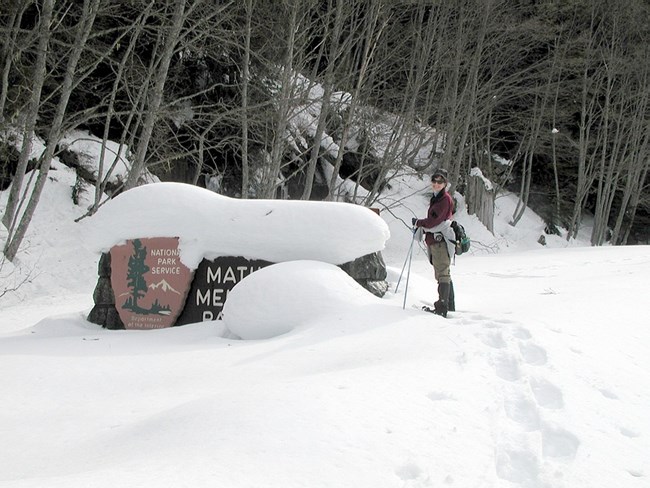 Volunteer snowshoeing at Mather Memorial Sign