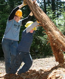 Mother-and-son volunteers work on clearing debris from a damaged section of the Wonderland Trail near Cougar Rock Campground