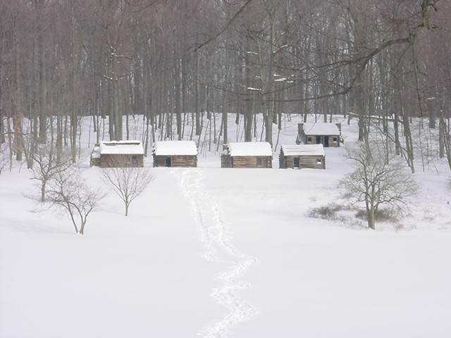 Photo of the reconstructed solider huts at Jockey Hollow covered in snow