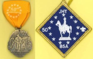 medal hanging from a yellow ribbon and a blue diamond shaped patch with a horse and rider embroidered on it in white.