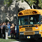 Image of a school bus and students in front of the site.